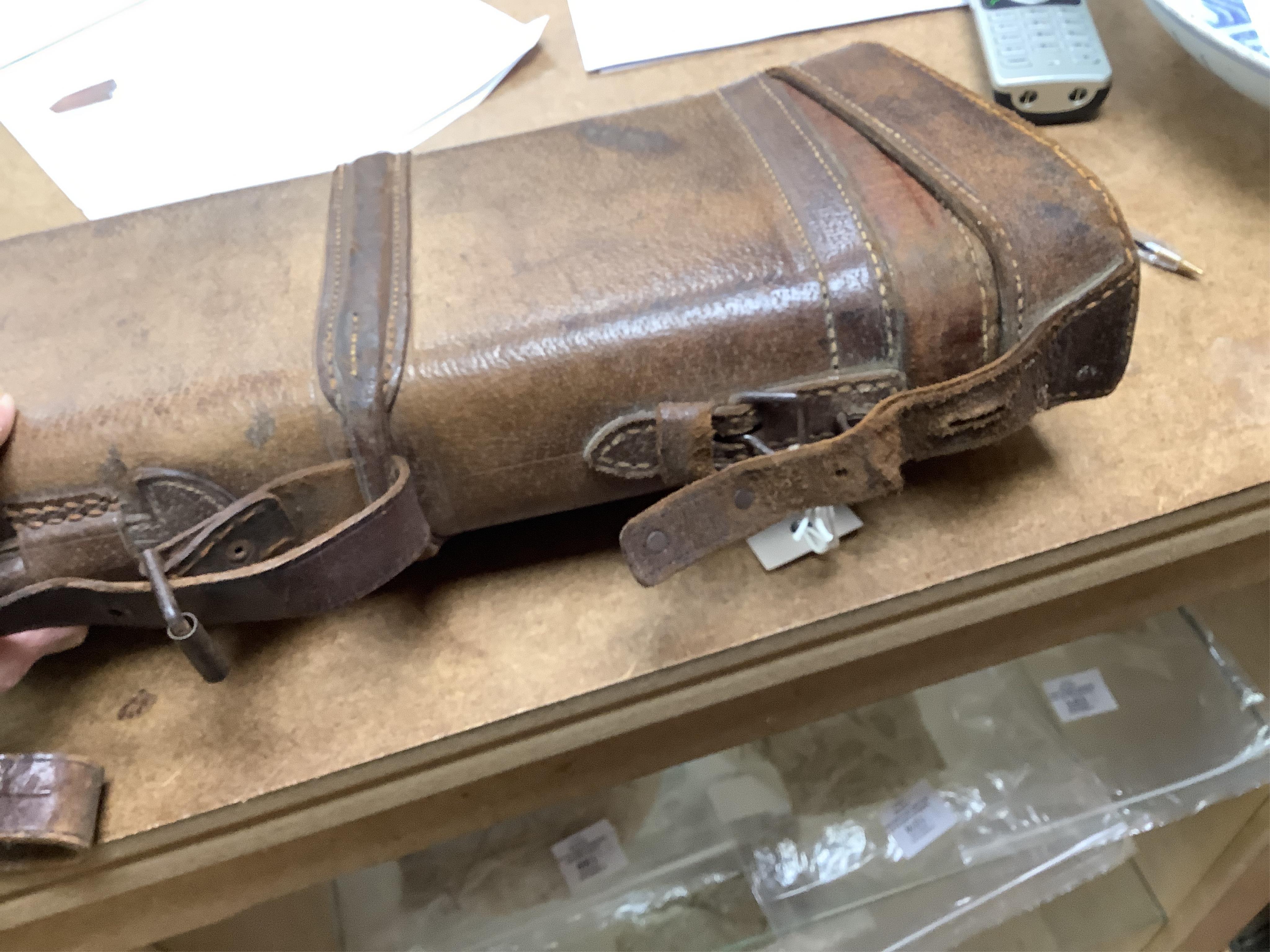 A 'Leg of Mutton' leather gun case and a top hat in leather case, gun case 75cm long.